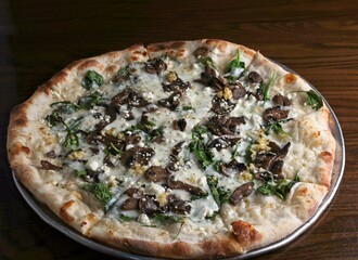 Gourmet pizza white pie with baby spinach, roasted mushroom, fresh garlic & goat cheese.Finished...