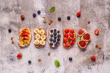Homemade summer toast with cream cheese, nut butter and fruits and berries