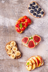 Homemade summer toast with cream cheese, nut butter and fruits and berries