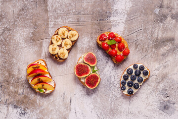 Homemade summer toast with cream cheese, nut butter and fruits and berries