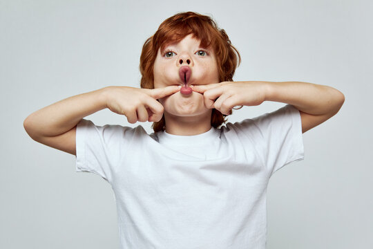 Grimacing Redhead Boy Open Mouth Squeezing Cheeks Studio Cropped 