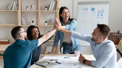 Overjoyed employees team giving high five, celebrating success, business achievement, great...