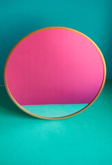 single round mirror  on green and blue background and pink and blue reflection in the mirror. color block mock up