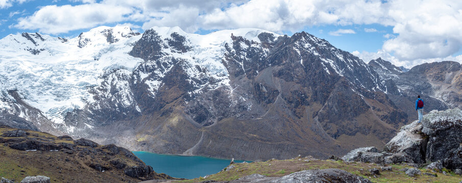Panorama landscape of man standing in a rock during hike/trail with huge mountains with snow and a lake with blue sky and clouds, in cordilera Huaytapallana, Huancayo, peru © José Rego