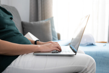 Fototapeta premium Close up engineer woman hand is using laptop for work with blueprint and hard hat background.