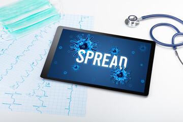 Tablet pc and doctor tools on white surface with SPREAD inscription, pandemic concept