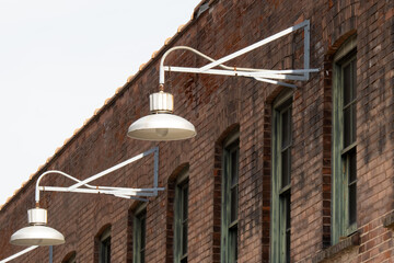 Old style metal light fixtures on an old brick warehouse wall