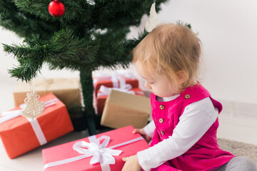 Fototapeta na wymiar Baby holding Christmas gift. Winter holidays concept.
