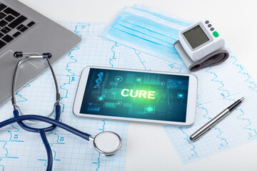 Tablet pc and medical stuff with CURE inscription, prevention concept