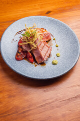 Tuna fillet on a parrilla with rostized jitomate in marmol plate. Gourmet tuna fillet