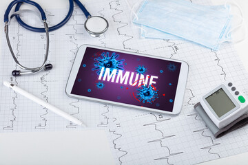 Tablet pc and doctor tools on white surface with IMMUNE inscription, pandemic concept