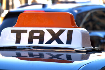 an orange and white unbranded taxi roof sign with its reflection