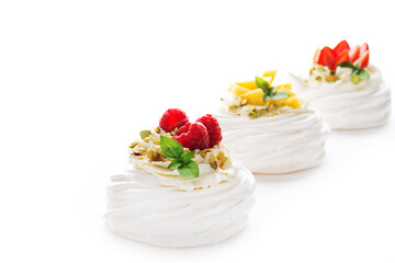 Individual cake dessert Anna Pavlova with berries and cream on a white background