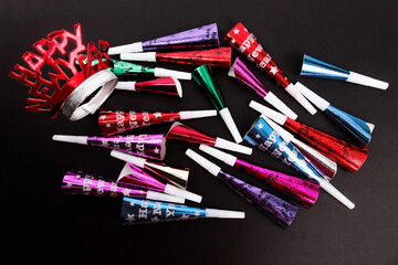 colorful new years noise maker horns and whistles isolated on black