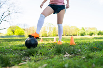Young female soccer player practicing on field.