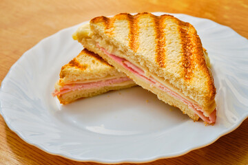 Ham and cheese toast on white plate