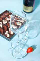Empty glasses for champagne or wine. box of chocolates and bottle on the background
