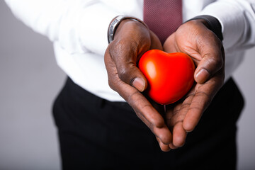 Male doctor holding a red heart in his hands. Cardiology concept