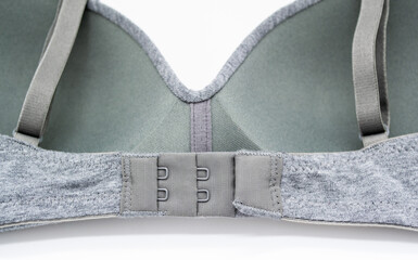 Simple grey bra on a white background. Wrong side, wrong side of underwear , hook-and-eye closure