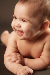 hermosa bebe latina ri&eacute;ndose muy feliz con un fondo oscuro