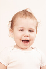 retrato de hermoso bebe blanco cauc&aacute;sico de menos de un a&ntilde;o  mir&aacute;ndo a c&aacute;mara con una gran sonrisa  sobre fondo blanco