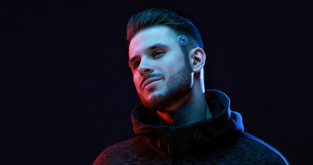 Young man with beard. Portrait of guy on dark backgound. Augmented reality, future technology...