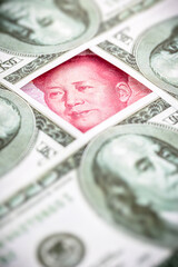 yuan banknote, surrounded by 100 dollar bills. American market protectionism concept