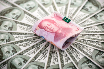 American money banknotes around a Chinese money bill, concept of yuan versus dollar