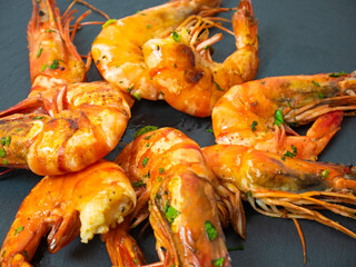Grilled prawns, grilled prawns with sauce and herbs, fresh grilled shellfish on a slate plate for appetizers
