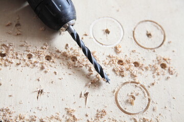 Special spiral drill bit on wood in electric drilling machine on wooden background, DIY drilling...