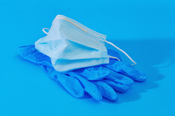 blue medical gloves and medical face mask  on blue background