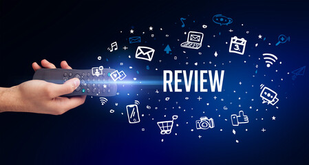 hand holding wireless peripheral with REVIEW inscription, social media concept