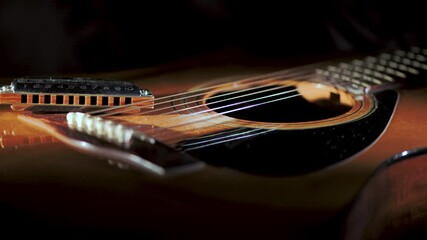 Country blues harmonica resting on top of acoustic guitar