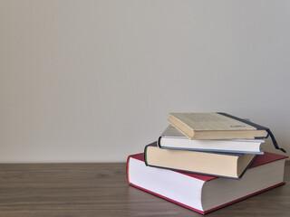 Stack of books on a table with light colored background.Education learning and reading concept