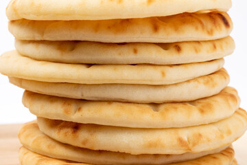 close up a stack of Naan bread on a wooden board isolated on a white background