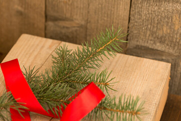Christmas composition. Christmas tree branch and red ribbon on a wooden background.