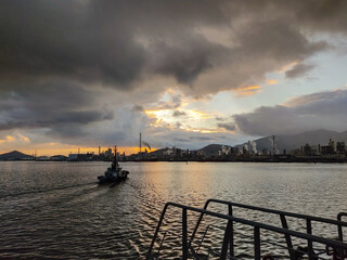sunset over the harbor with tugboat
