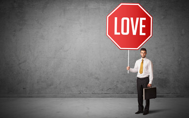 Young business person holding road sign with LOVE inscription, new rules concept
