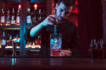 Bartender mixing cocktail in pub