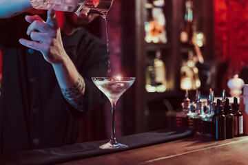 Bartender mixing cocktail in pub
