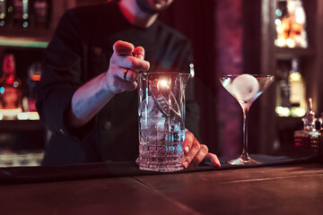 Detail of unknown bartender mixing cocktail in pub
