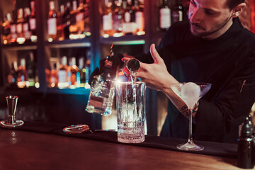 Bartender mixing cocktail in pub