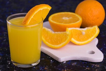 
A glass of freshly squeezed orange juice on a white wooden board.
Close-up.