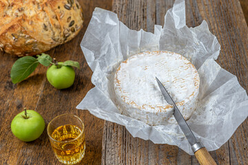 Sliced round camembert cheese traditional french milk creamy dairy product with fresh aromatics...