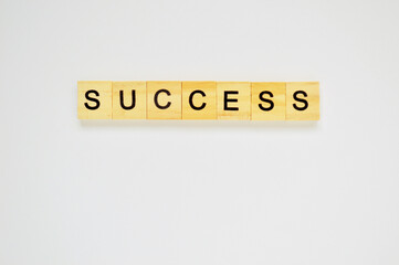 Word success. Wooden blocks with lettering on top of white background. Top view of wooden blocks with letters on white surface