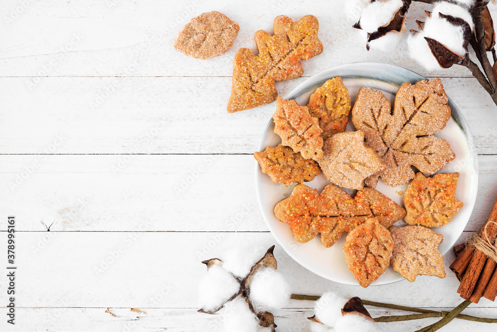 Wall mural autumn leaf sugar cookies. overhead view side border on a white wood background with copy space.