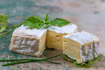 A block of Pont-l eveque French Normandy cheese resting on wooden board