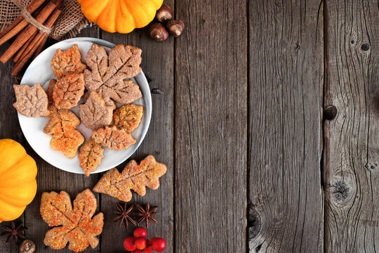 Autumn leaf sugar cookies. Top view side border on a rustic wood background with copy space.