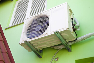 External air conditioning machine placed on the wall of a house