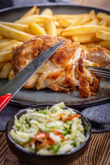Fried chicken breast stuffed with bacon and cheese served with chips and salad.